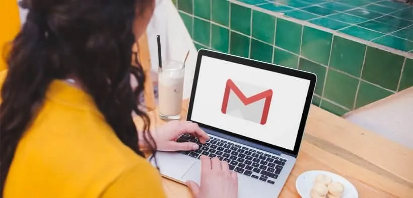Vrouw achter de laptop met op het scherm het Gmail-icoon