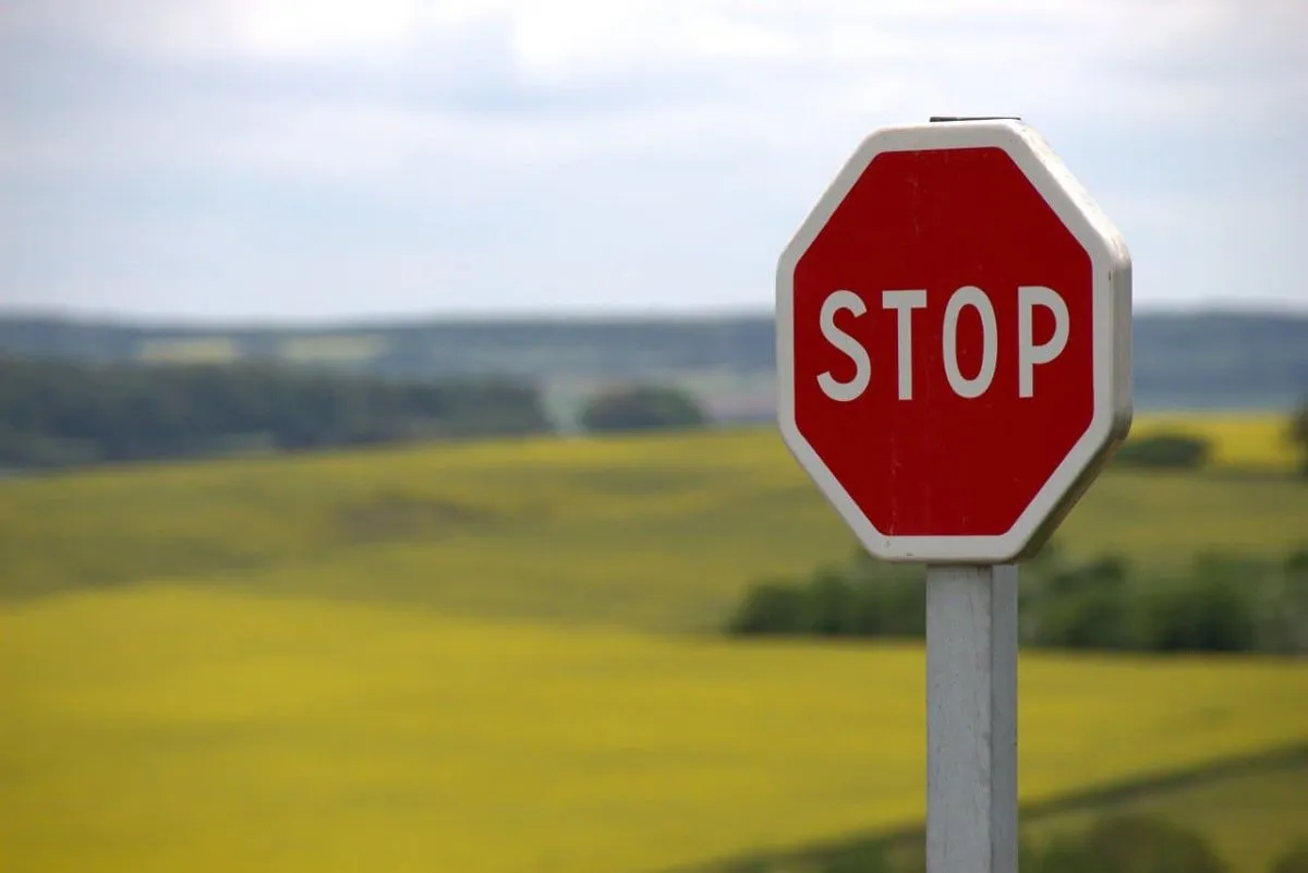 Stopbord op paal met platteland op achtergrond