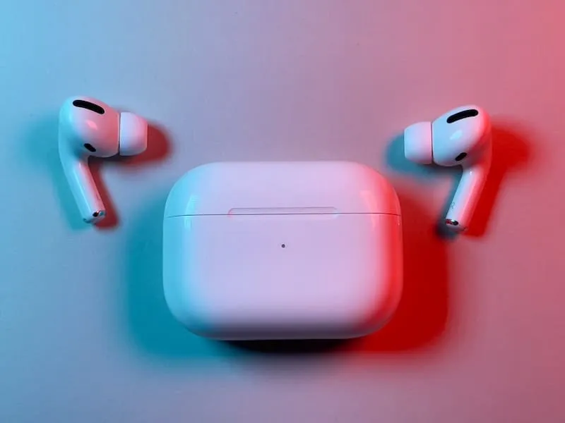 AirPods Pro houder met de oordopjes ernaast in neonlicht